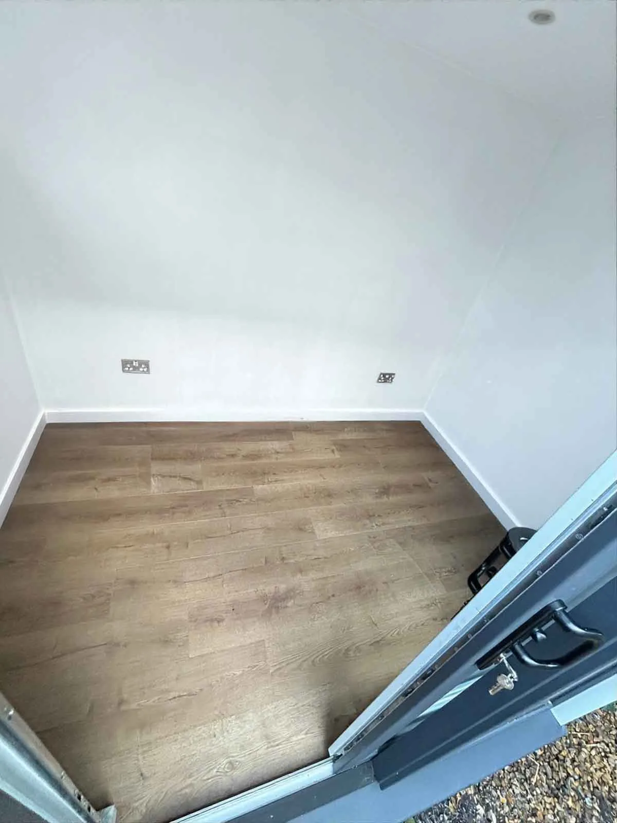 Compact garden pod interior — plastered walls and fitted flooring
